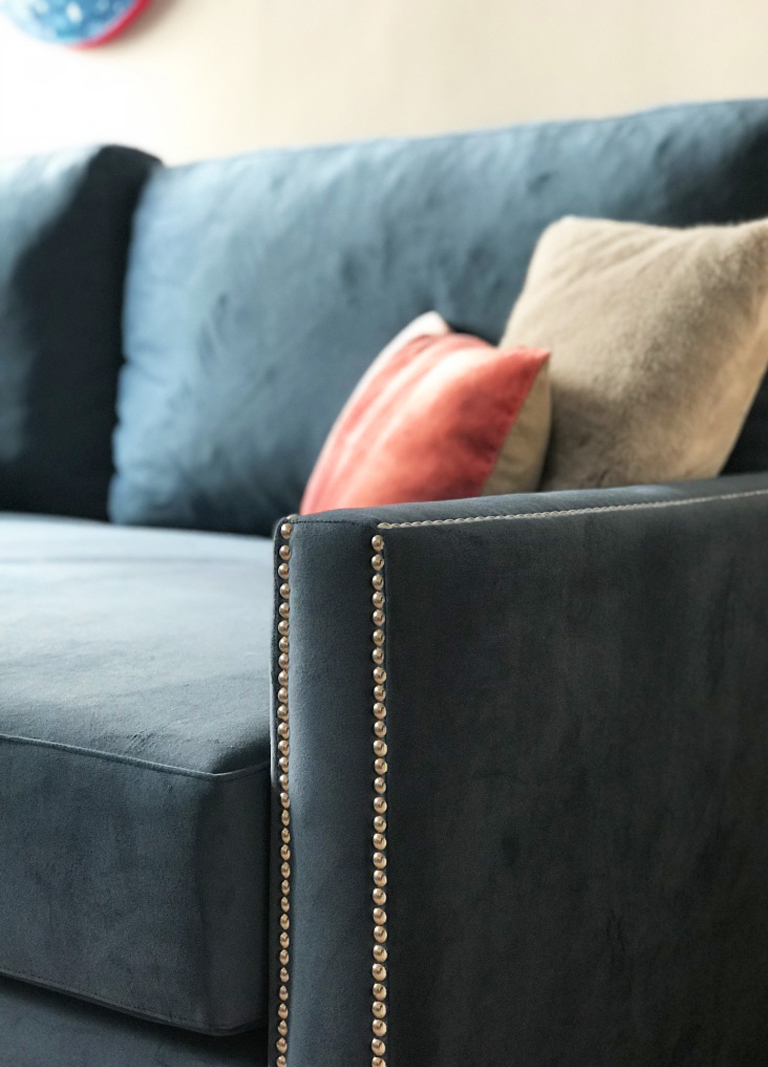 Detalle de sofá del salón con tachuelas y tela de terciopelo azul