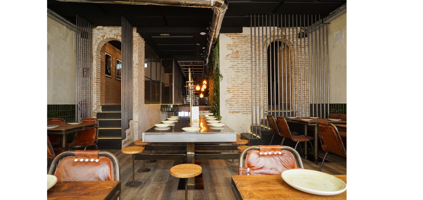 Rehabilitación de restaurante con paredes de materiales originales, ladrillo e instalaciones vistas