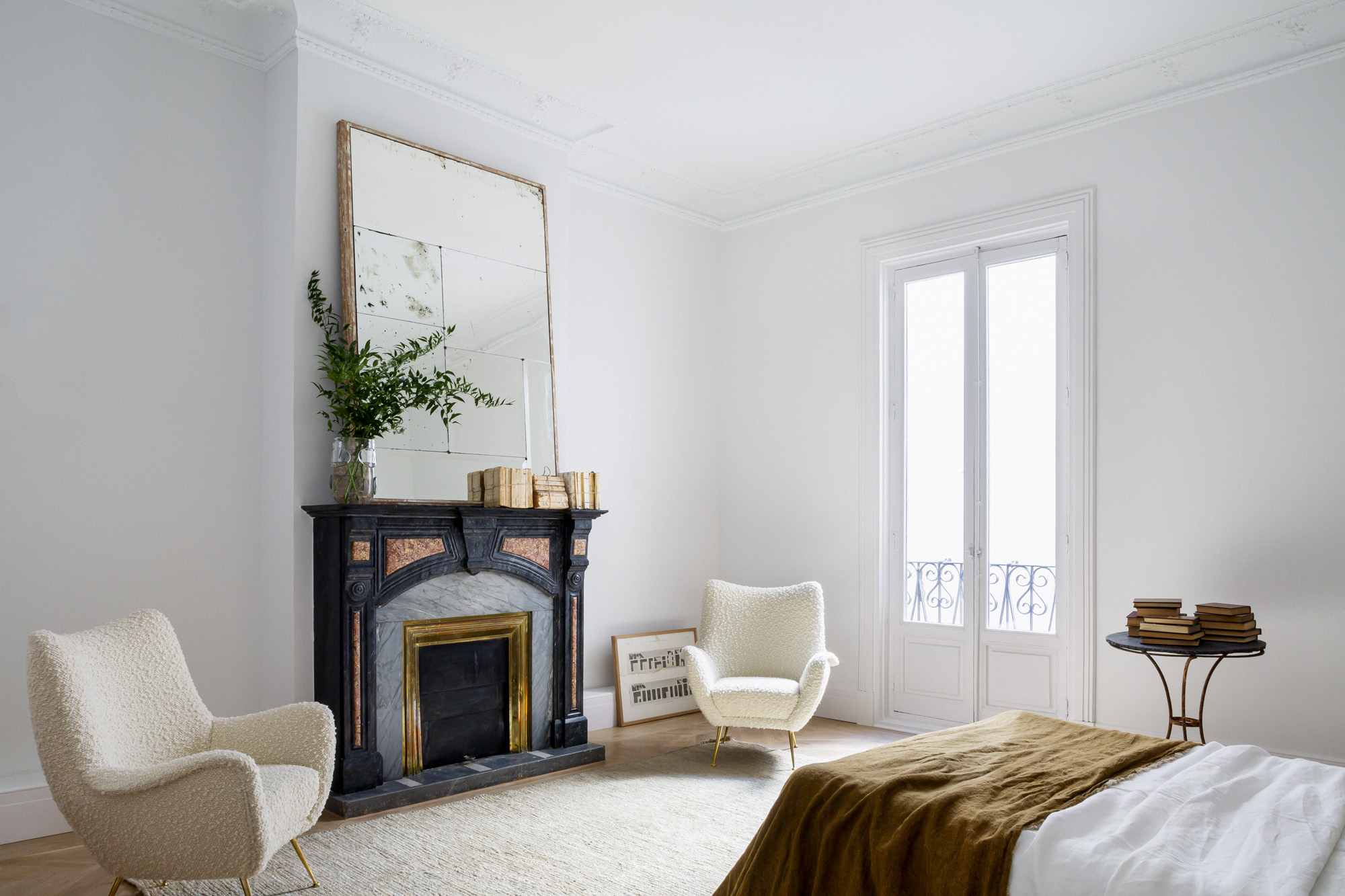 habitación principal luego de la reforma con chimenea orginal, molduras de techo restauradas y decoración sencilla y moderna