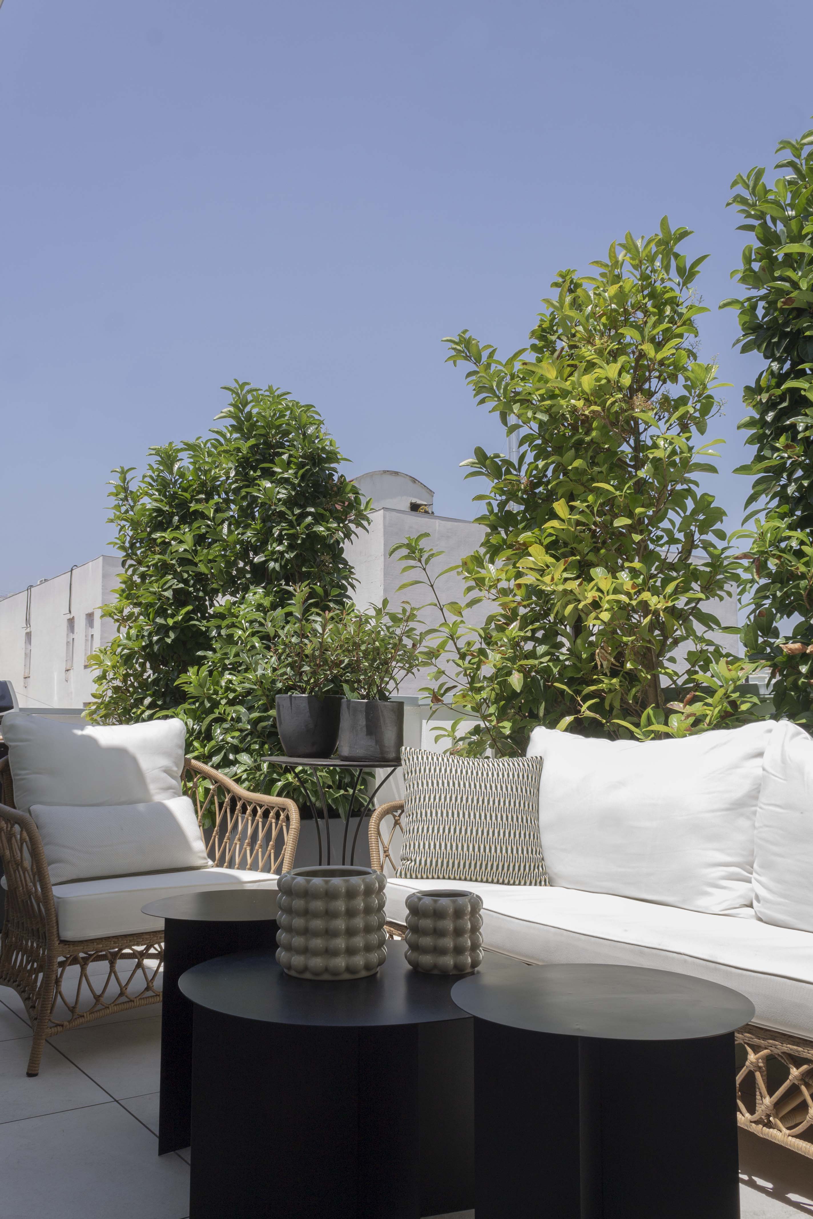 Vista de la terraza del duplex en el centro de Madrid, con mobiliario de terraza y vegetación alta para dar más privacidad