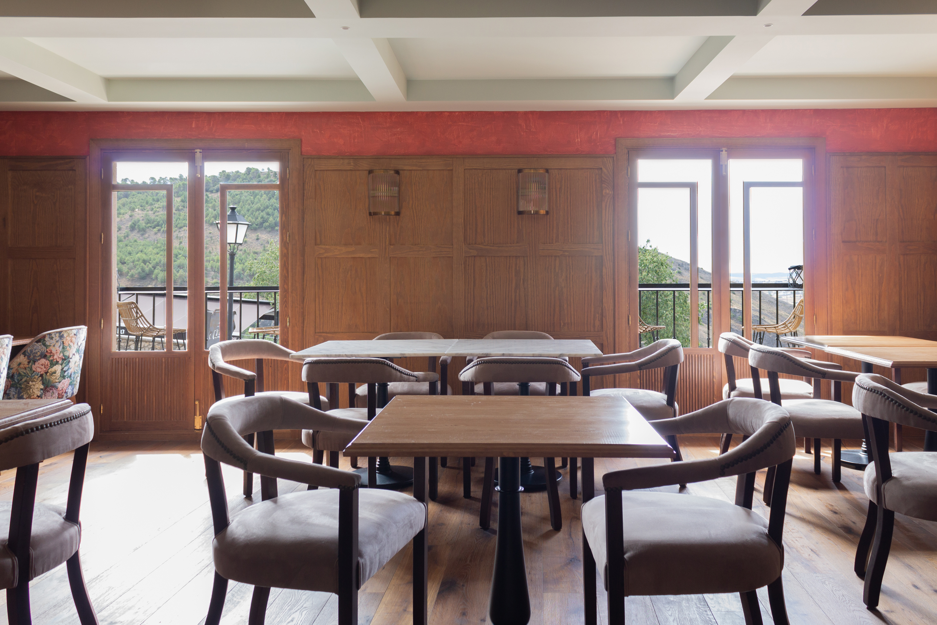 Vista del comedor de primera planta con zócalos de madera y balcones con las mejores vistas